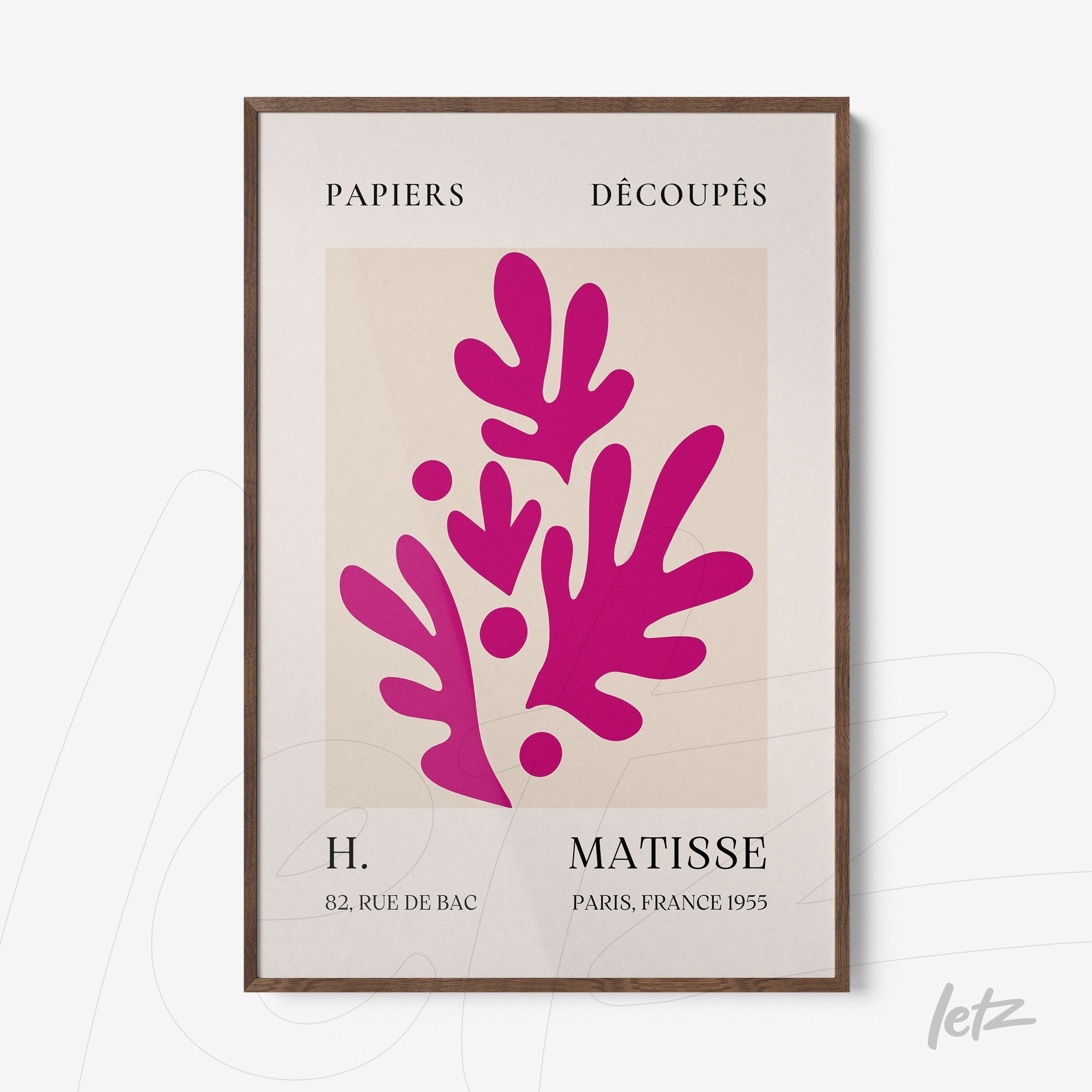 modern framed art of paper cutouts in vibrant pink on light background, dark wood frame