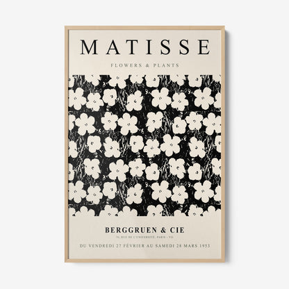 framed wall art featuring a stylized floral pattern in white on a black background with a light frame