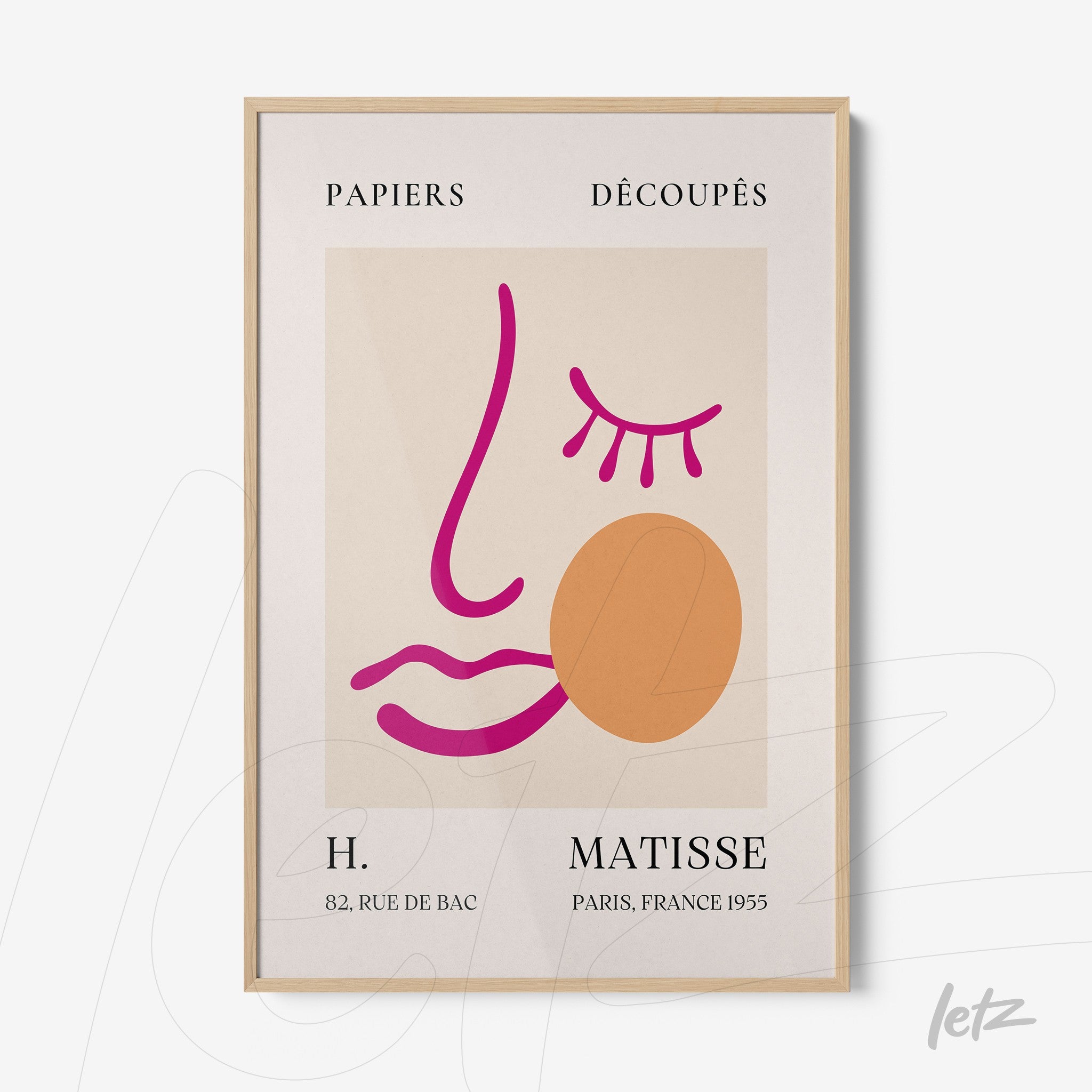 framed modern art piece featuring a stylized face in pink and orange tones with a light wood frame
