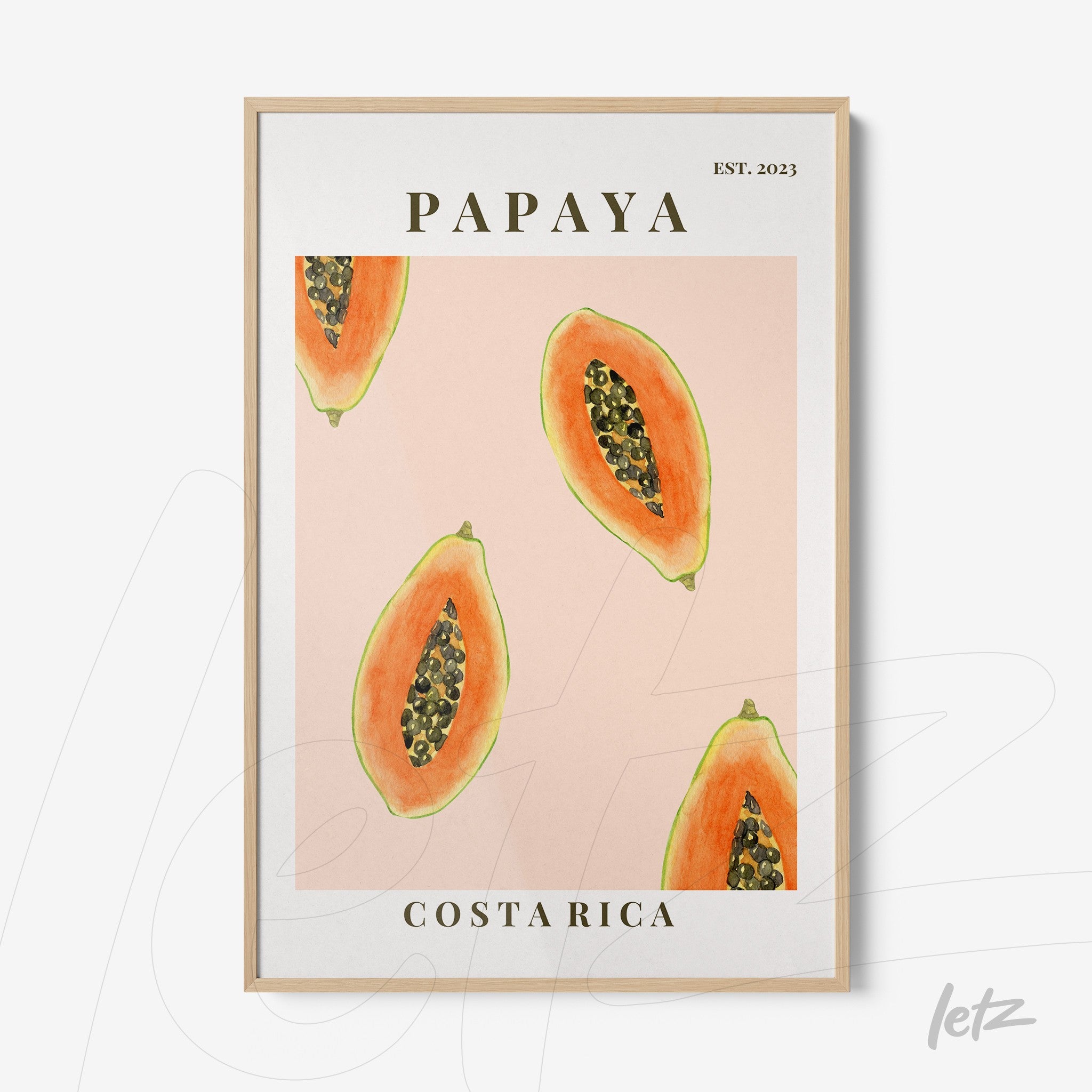 framed art print featuring slices of papaya on a pink background with light wood frame